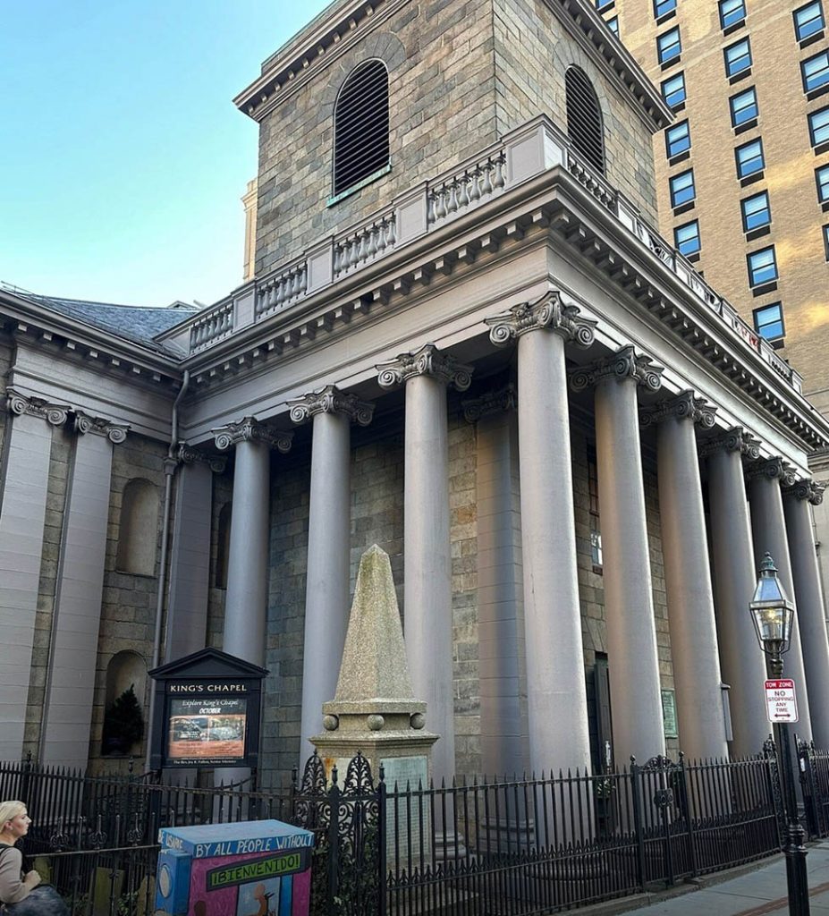 A majestic stone building with columns and a clock tower, standing tall in the cityscape - City View Trolley